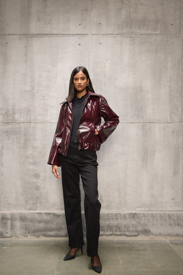 Woman wearing Freyja Burgundy Vegan Leather Bomber Jacket in an oversized fit.