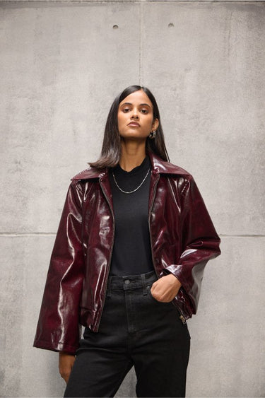Woman wearing Freyja Burgundy Vegan Leather Bomber Jacket in an oversized fit.