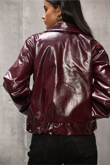 Woman wearing Freyja Burgundy Vegan Leather Bomber Jacket in an oversized fit.